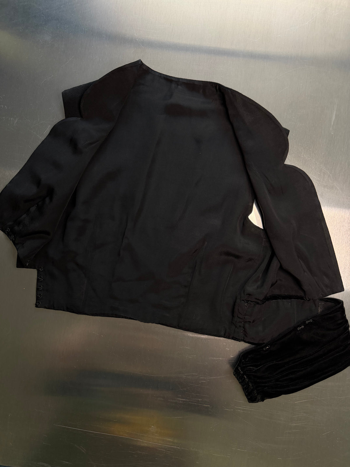 close-up of the satin interior lining of the black scalloped vest