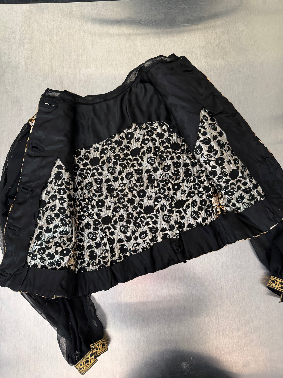 the gold brocade blouse turned inside out, showing the black and white patterned satin lining