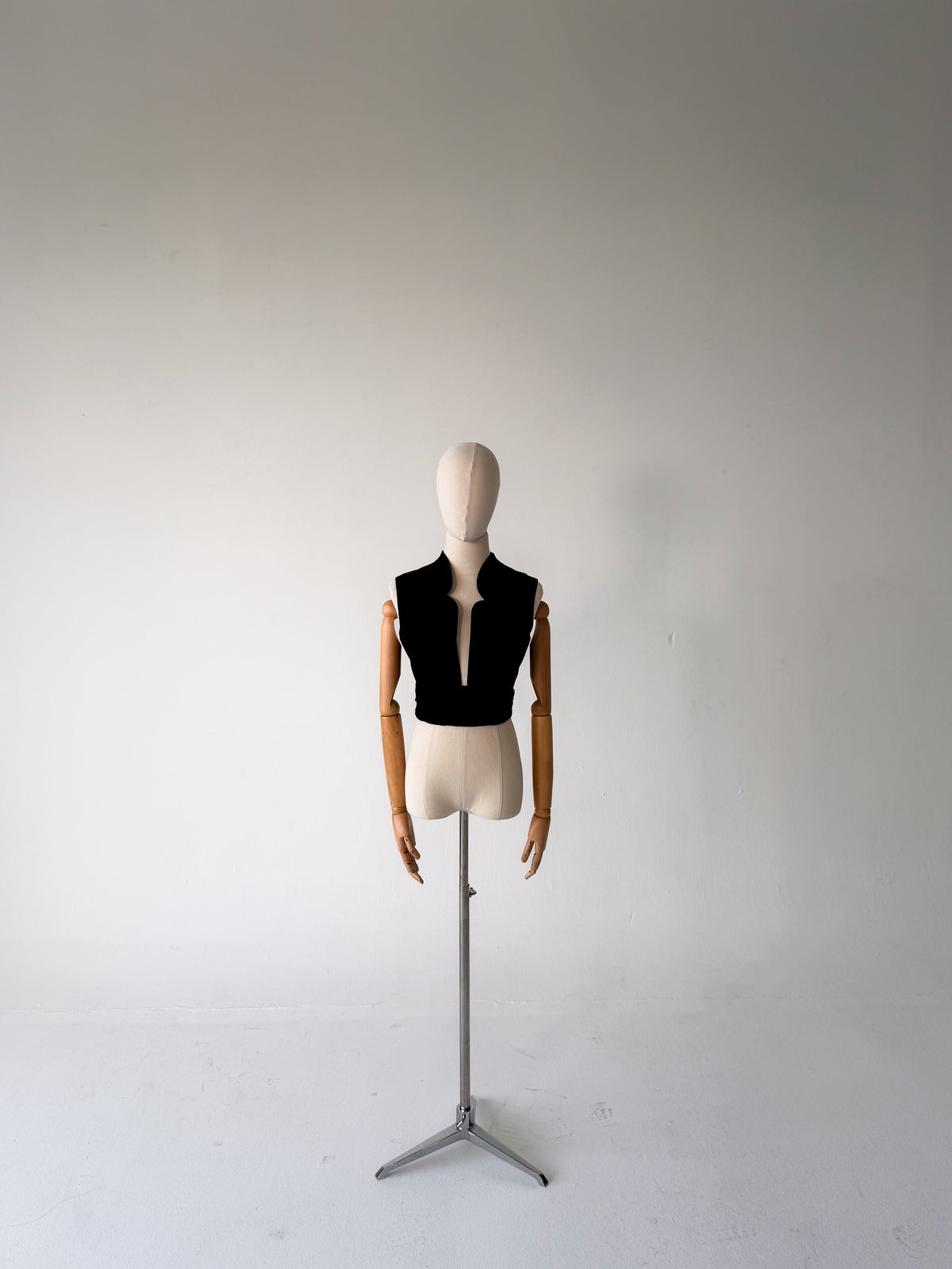 full-length front view of the black scalloped vest with velvet cummerbund, on a dress form on a tripod stand