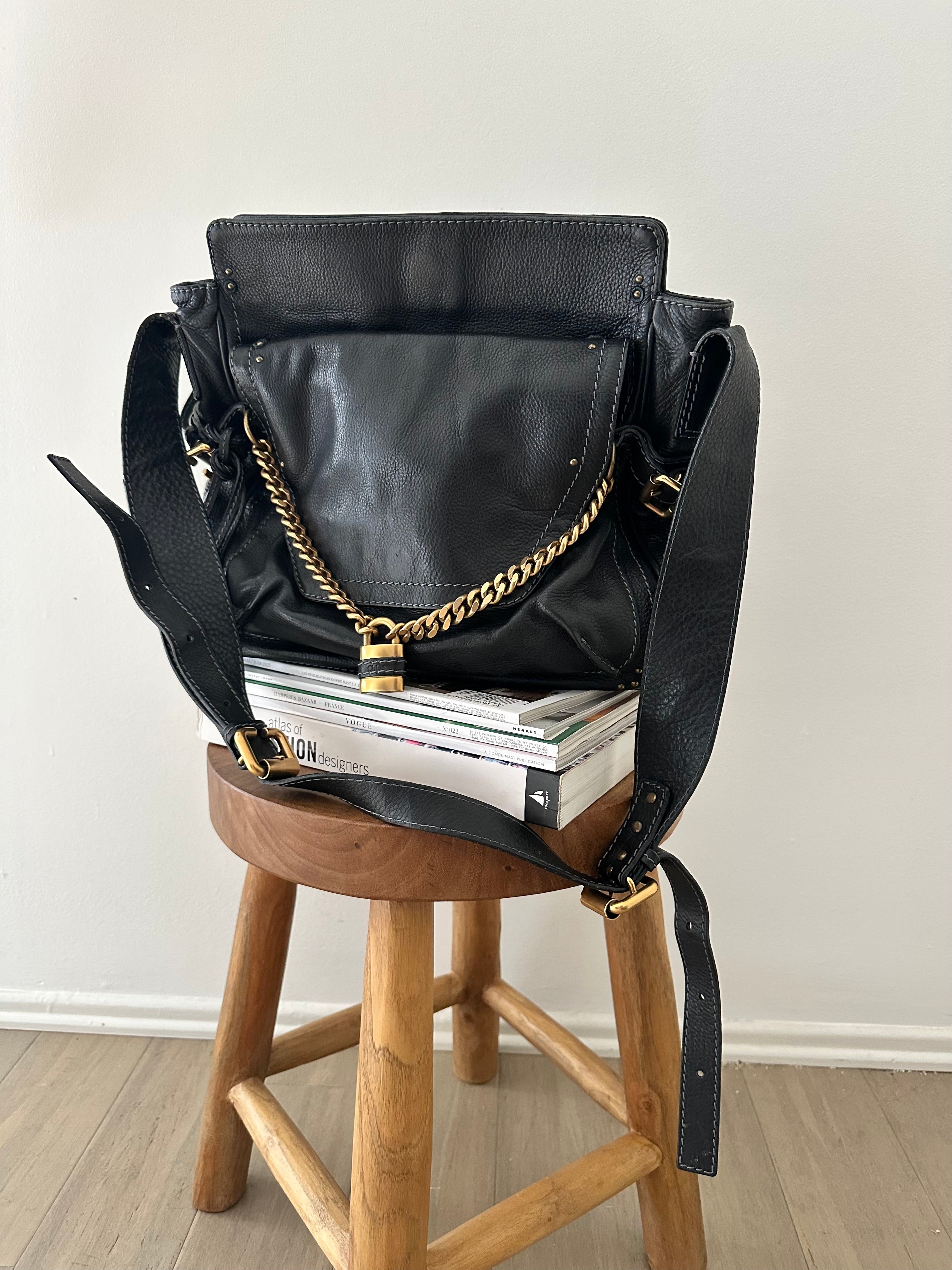 Chloé Paddington Capsule bag in black leather with antique gold chain strap, styled on wooden stool with fashion magazines, phoebe philo era 2005