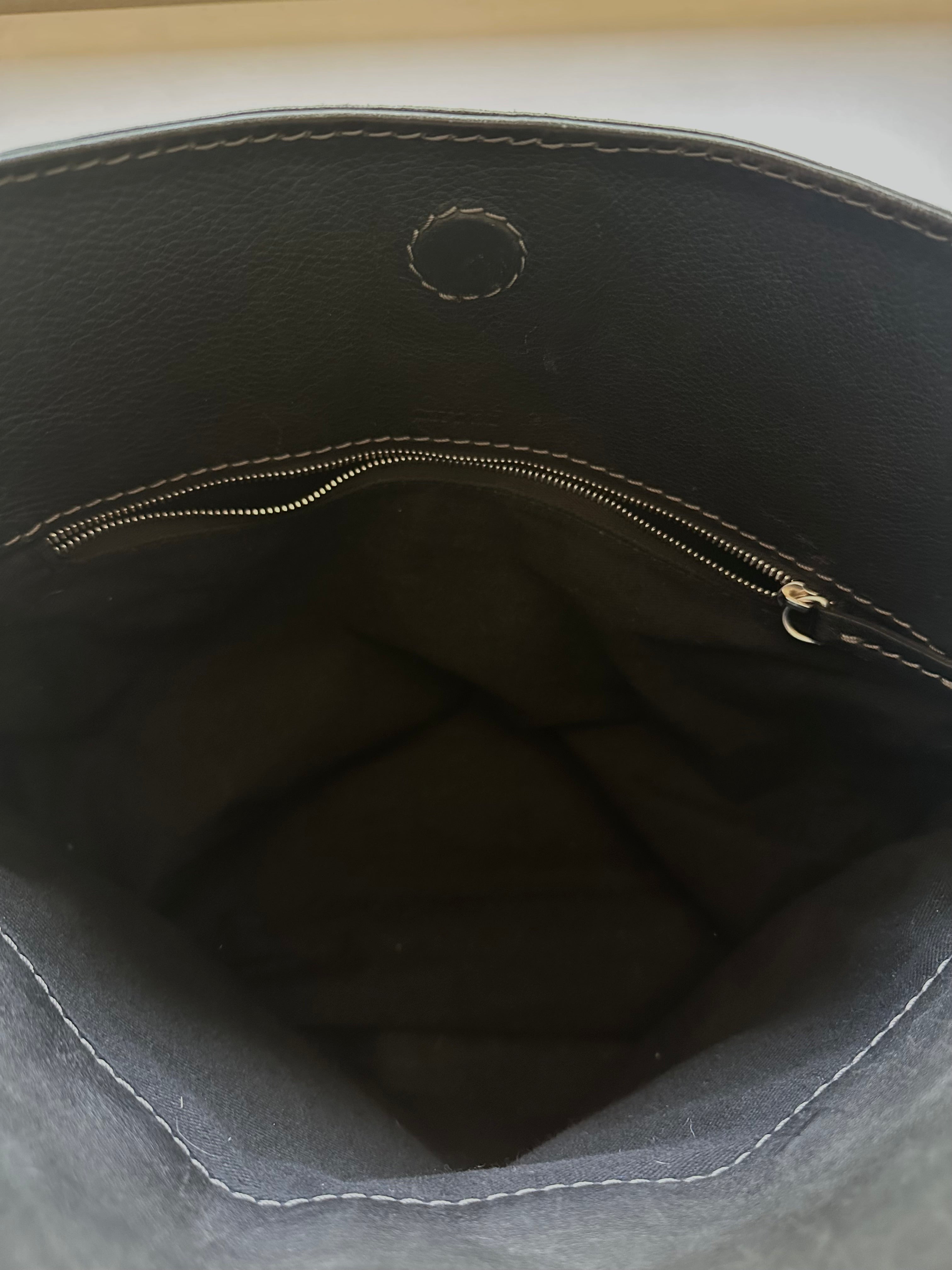 Close-up of magnetic snap closure detail on black Chloé Paddington Capsule bag interior panel