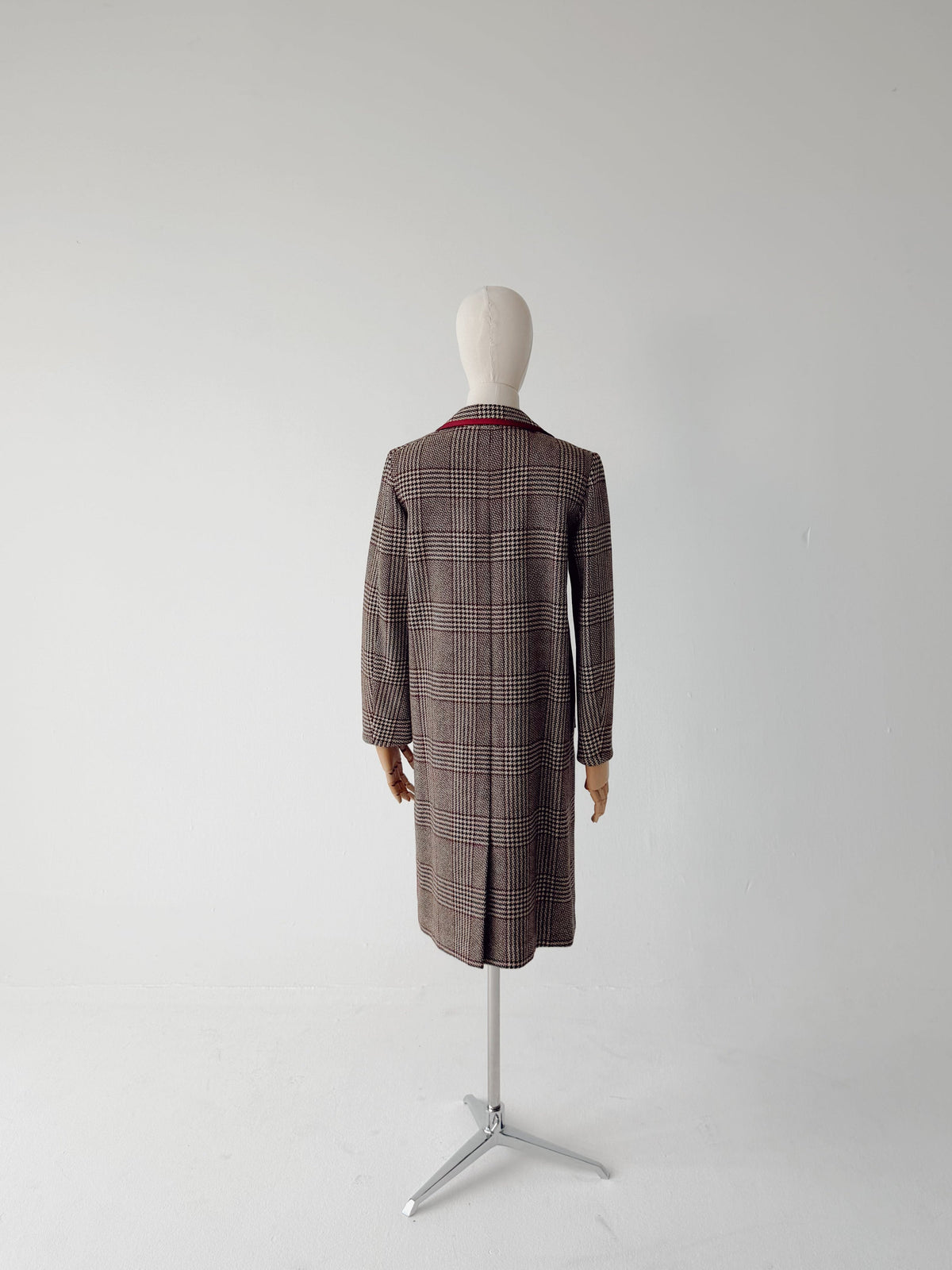 A long brown plaid coat displayed on a mannequin from the back, set against a plain white studio background.